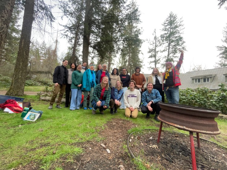 A group of people in colourful clothes with trees in the background