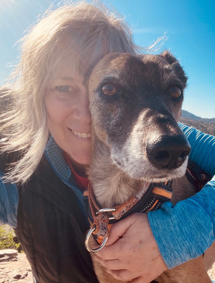 Close up of Christine hugging a dog 