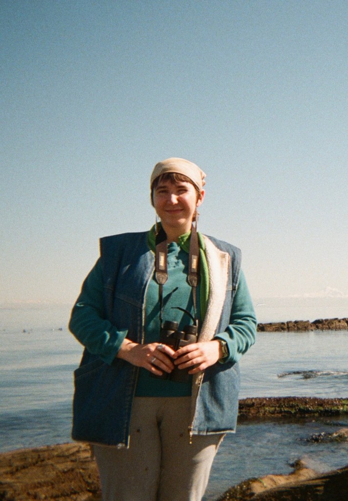 Headshot of Meghan standing in front of a large body of water