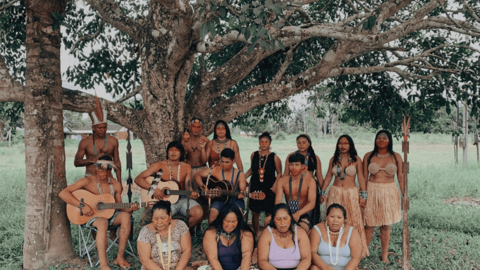 The Shanenawa people - around 15 of them, some in traditional dress from the Amazon region - gather for a photo under a large tree