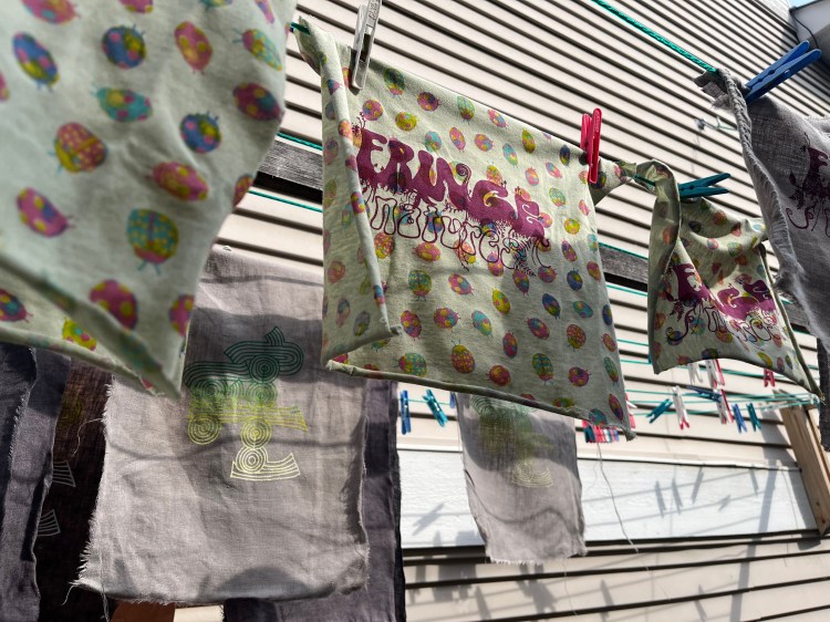 some colourful patches with "fringe natures" ad "FEELed Lab" screenprints hang from a clothesline