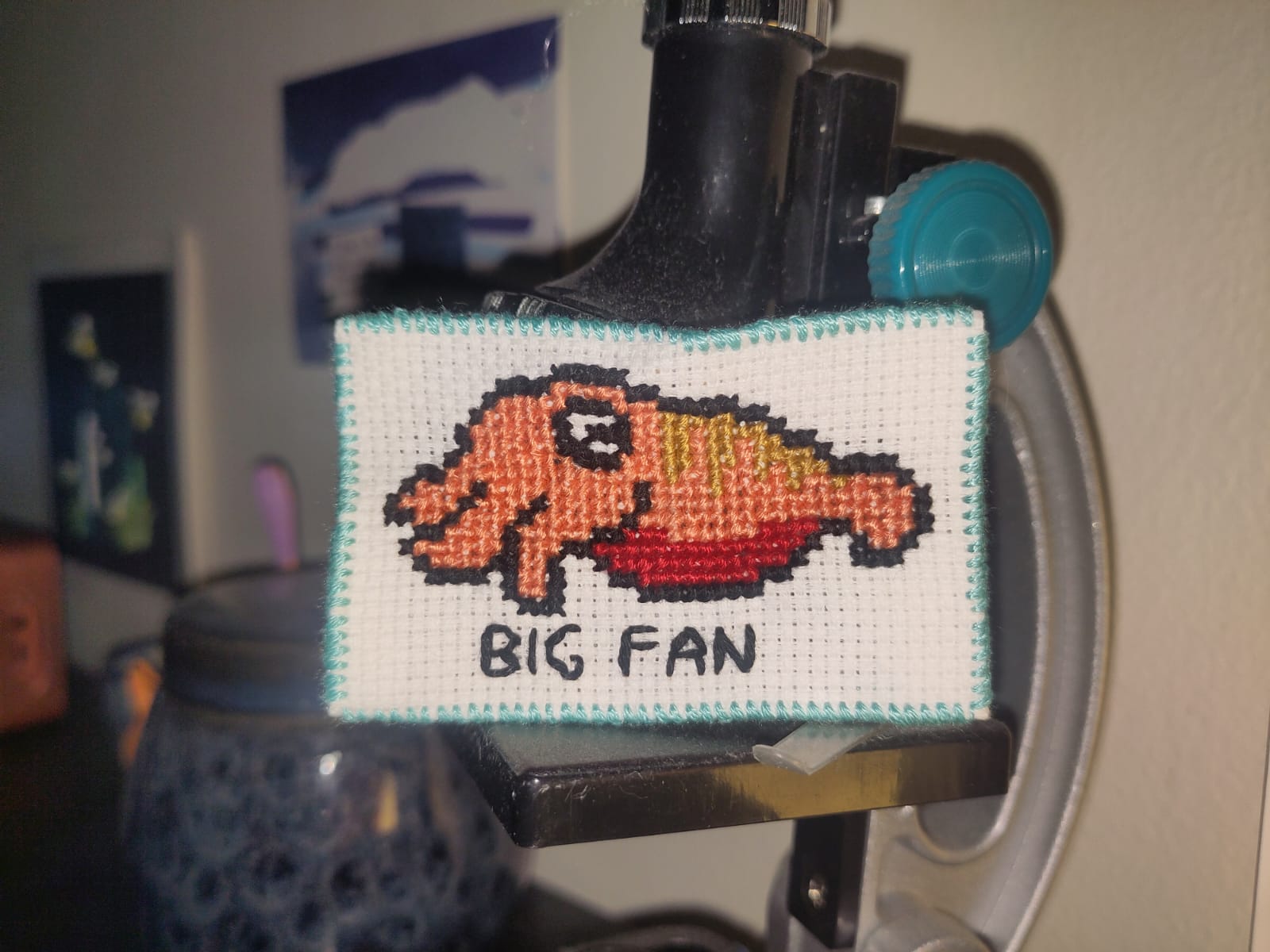 Cross-stitch patch of a cuttlefish with the text "BIG FAN"