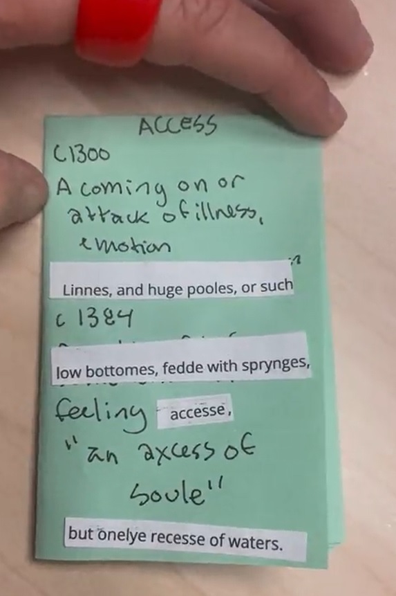 A hand with a chunky ring holds a green zine page titled “Access”. The official definitions of access are handwritten, with some portions covered over with text cut from magazine. The zine reads, “C1300: A coming on or attack of illness, emotion Linnes, and huge pooles, or such. C1384: low bottomes, fedd with sprynges, feeling access, ‘an axcess of soule’ but onlye recesse of waters.”