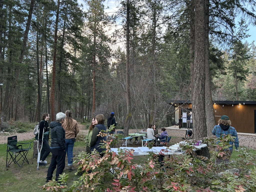 People mingling in the fire circle in front of the FEELed Lab next to a circle of chairs and tables