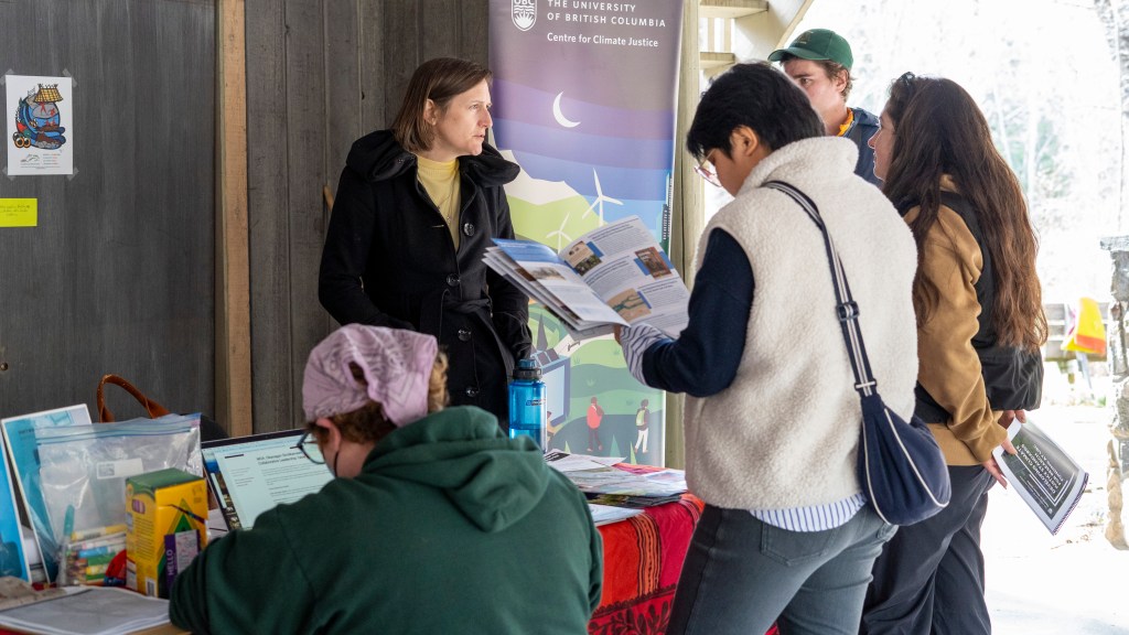 People browsing the CCJ exhibit table looking through the materials