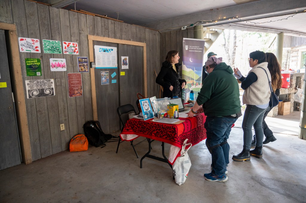 People browsing the CCJ exhibit table looking through the materials