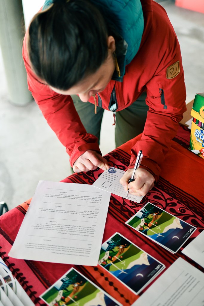 Someone writing a climate justice postcard