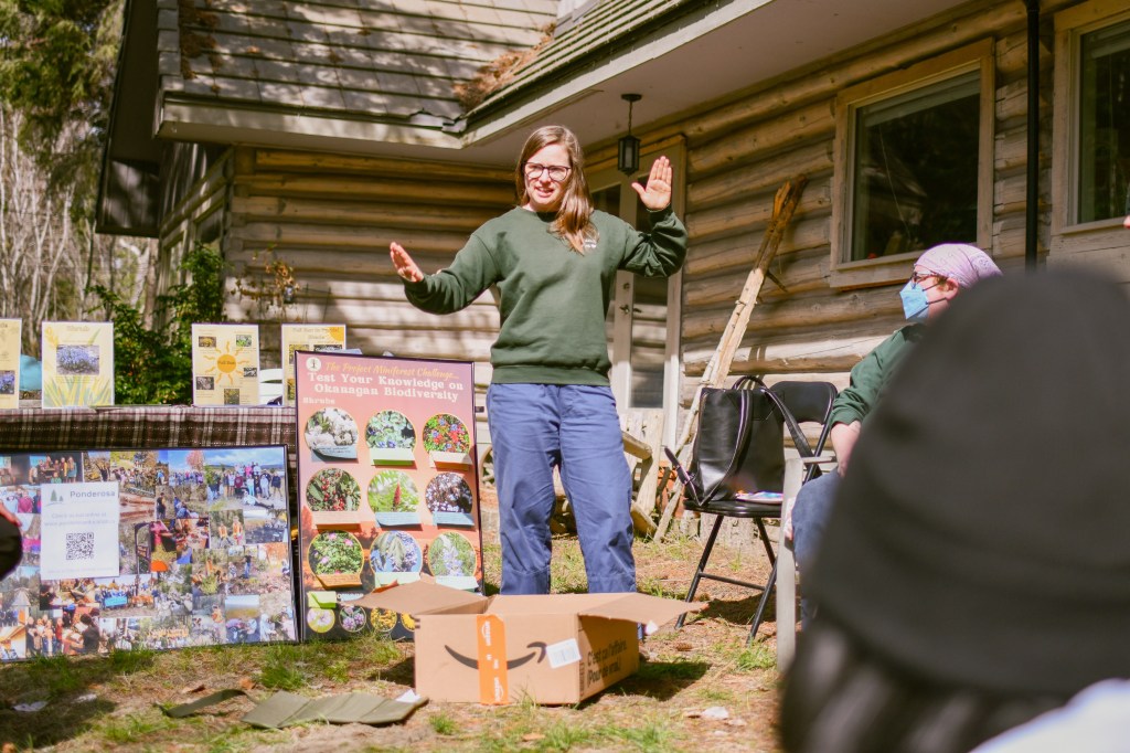 Jamie explaining the planting in front of a poster of native wildflowers