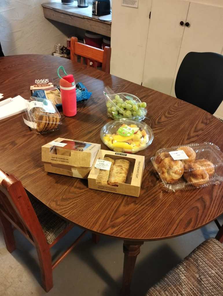 The kitchen table in the FEELed Lab filled with fruit and pastries