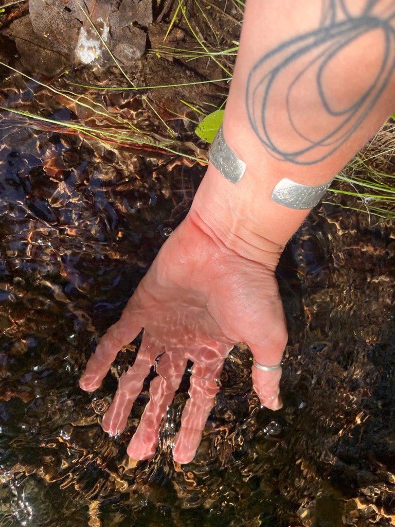 Photo credit: Astrida
A hand feeling the river
