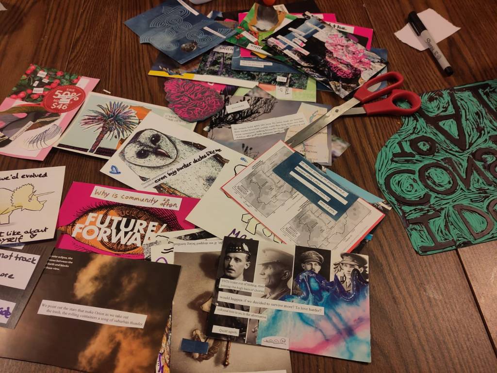 Crafting materials and postcards spread over the FEELed Lab kitchen table