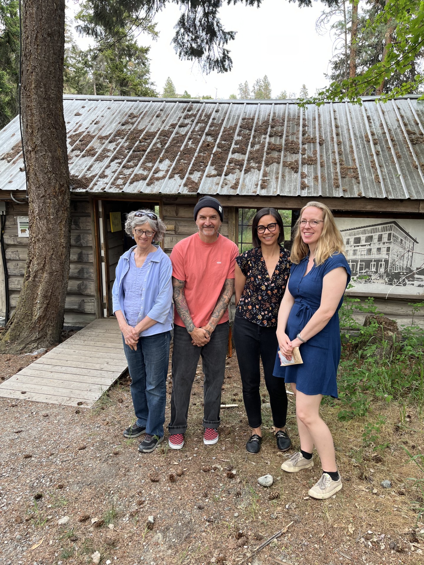 Four people standing in front of the schoolhouse