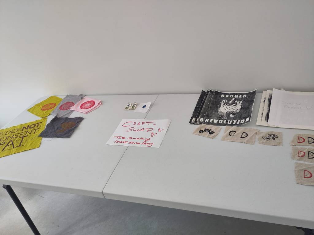 Craft-swap table with patches and posters.